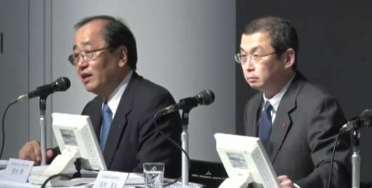 [写真]会見する高田重久会長（右）と清水博取締役