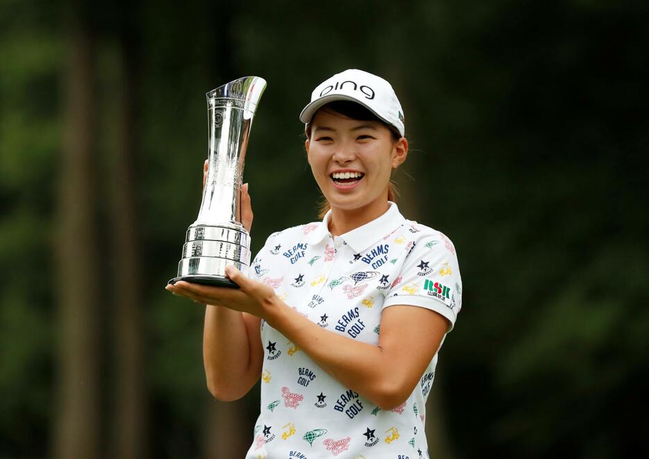 優勝トロフィーを手に笑顔を見せる渋野選手（写真：ロイター/アフロ）