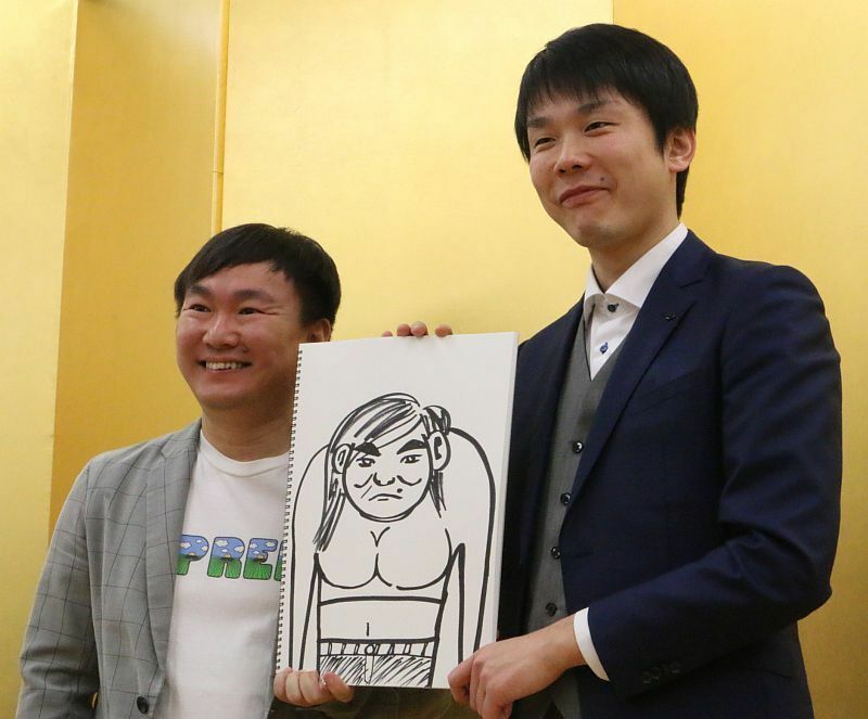 [写真]結婚を発表した山内健司（左）。相方の濱家隆一が描いてきた似顔絵とともに笑顔で撮影に臨む