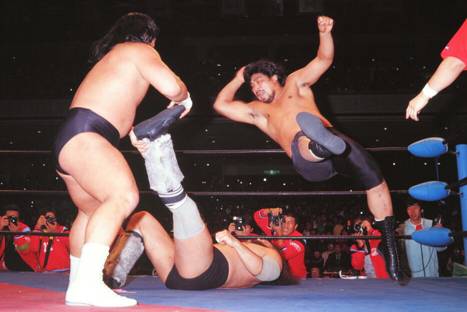 1985年、全日本プロレスのこけら落としで、長州力に足を固められたブルーザー・ブロディを目がけ、エルボードロップを見舞う谷津（写真：平工幸雄/アフロ）