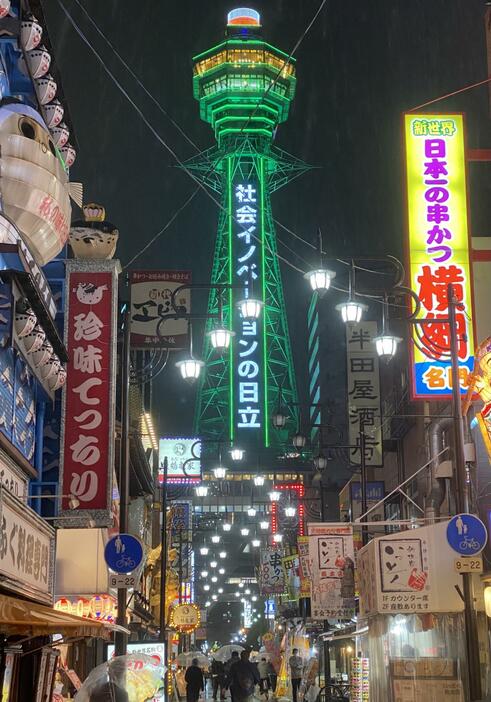 ［写真］降りしきる雨の中、緑色に輝く通天閣＝25日午後6時15分ごろ、大阪市浪速区で