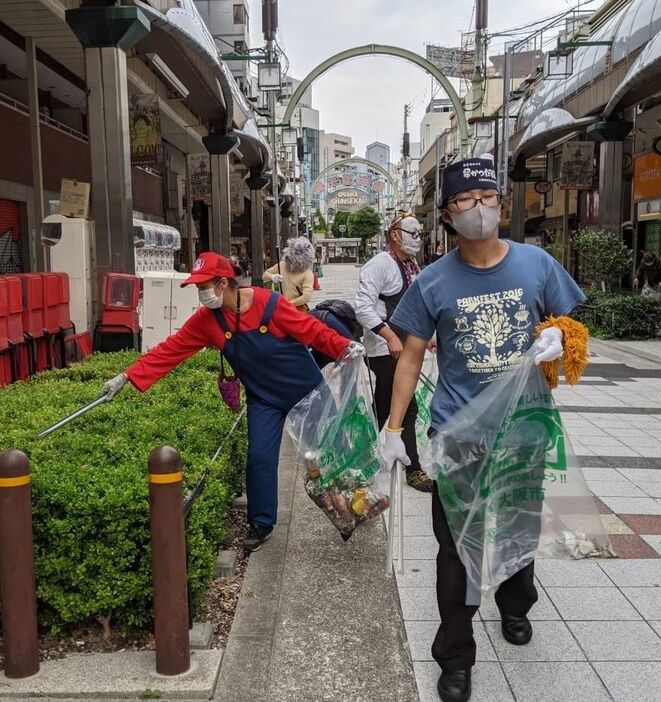 [写真]おなじみのキャラクター姿で清掃する新世界の店主たち＝27日午後、大阪市浪速区で（提供：新世界援隊）