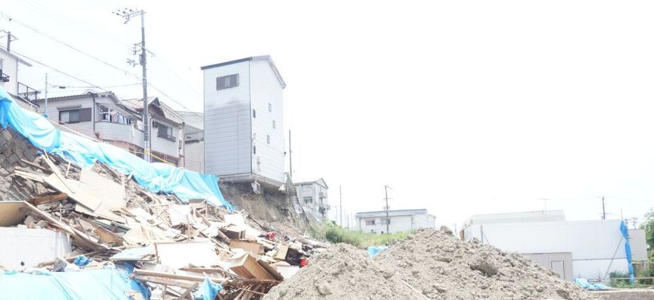 [写真]左側が残された住宅。右側の建物は保育園＝6月30日、大阪市西成区で