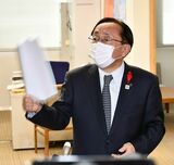 むつ市の中間貯蔵施設共同利用構想を巡る報道陣の取材の際、声を荒らげて資料を振り回す三村知事＝2020年12月