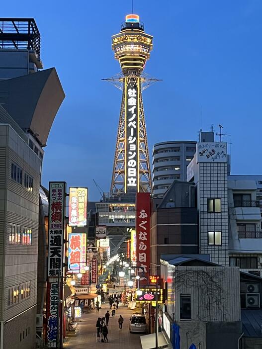 ［写真］大阪モデルの警戒を示す黄色信号を点灯周知する通天閣＝25日午後6時45分ごろ、大阪市浪速区で