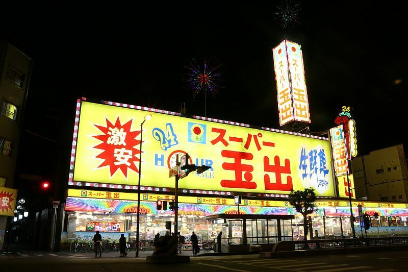 [写真]大通りに面し、地下鉄駅前のスーパー玉出花園店。24時間営業だという＝13日夜、大阪市西成区で