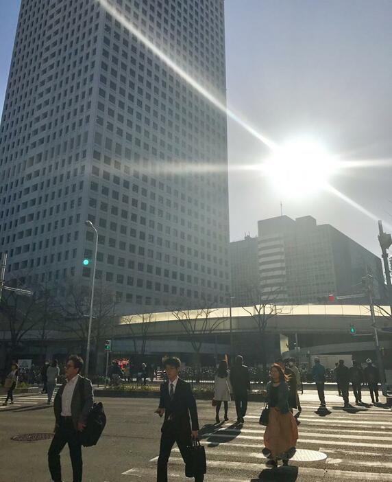 ［写真］強い日差しを受け歩く人の姿が多く見られた。左後方の高層ビルは大阪駅前第3ビル＝14日午後4時ごろ、大阪市北区で（撮影:柳曽文隆）