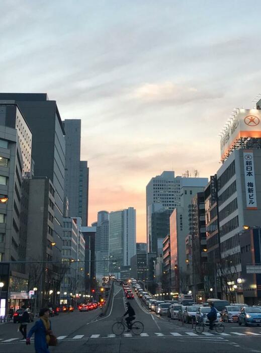 [写真]日が沈み少し肌寒くなると、マフラーやコート姿で家路を急ぐ人の姿が多く見られた＝12日午後6時ごろ、大阪市北区で