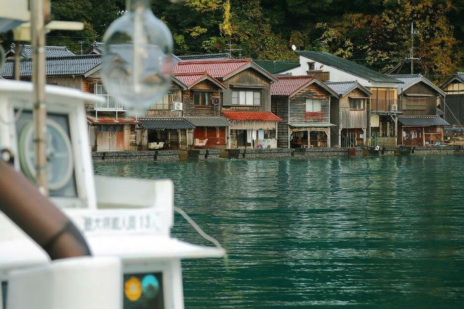 穏やかな水面に舟屋の佇まいが映り込む