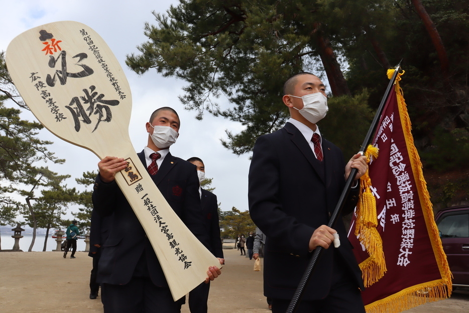 大しゃもじやセンバツ旗を手に歩く広陵の選手たち＝広島県廿日市市で、安徳祐撮影