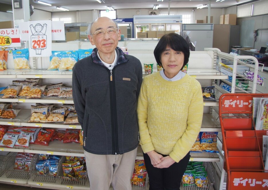 社高校の正門前で長年続けてきた店を閉じる高田光夫さんと妻恵さん＝加東市社で２０２３年２月２５日