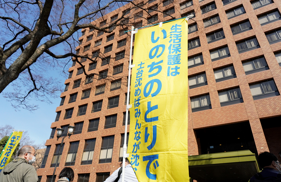 名古屋高裁の前で基準引き下げ決定の取り消しを訴える原告の支援者ら（写真：関口威人）