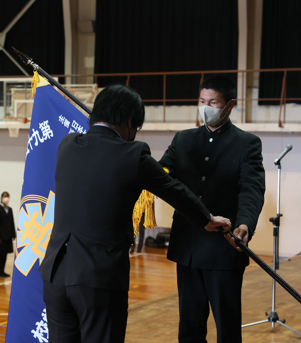 毎日新聞山口支局の内田支局長（左）からセンバツ旗を受け取る升田主将