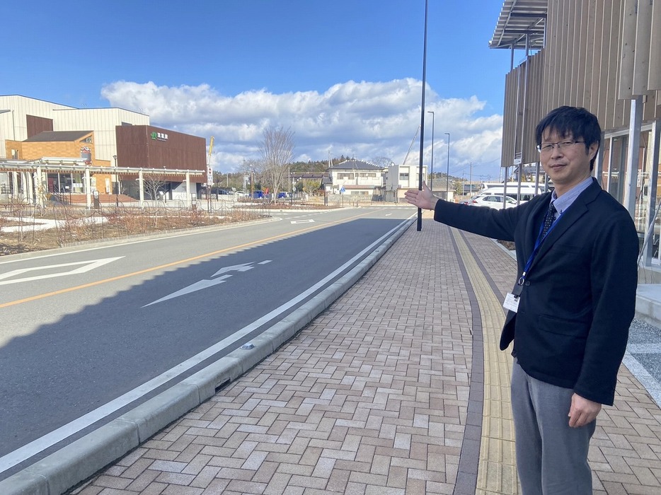 双葉町役場　（右）と双葉駅（左）を案内する双葉町の応援職員の土井英資さん