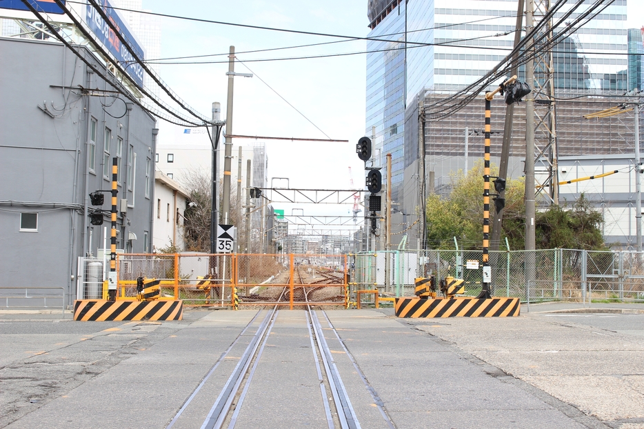 ［写真］3月16日現在、JR東海道支線踏切跡付近の線路に立ち入れないようフェンスが張られている＝16日午前、大阪市北区で