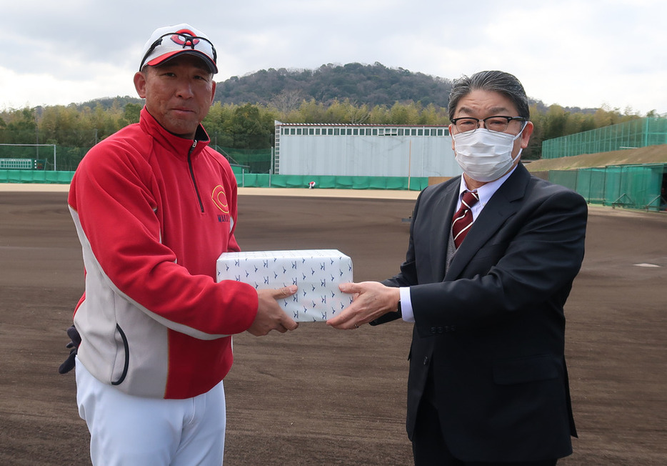 中谷監督（左）に練習用ボールを贈呈する宮井会長＝和歌山市の智弁和歌山高校で２０２３年３月３日午前１０時５分、勝野俊一郎撮影