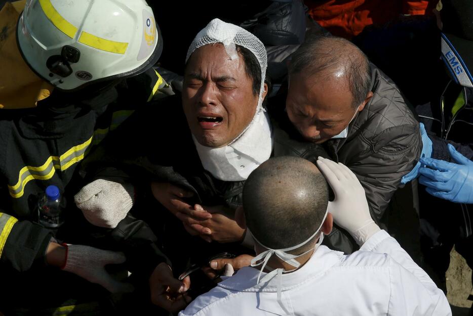 家族の死を知らされて悲嘆にくれる生存者＝2016年2月7日（写真：ロイター/アフロ）