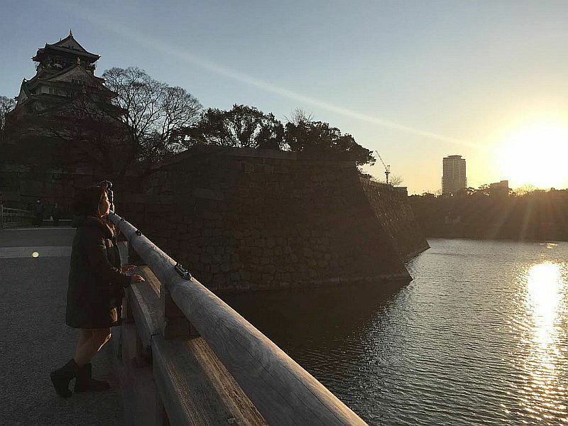 [写真]夕陽をあびた大阪城（左上）とお堀に夕陽が映る=25日夕、大阪市中央区で