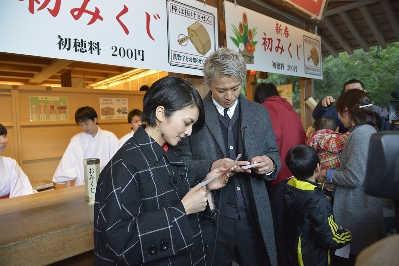 [写真]参拝後、おみくじをひく二人