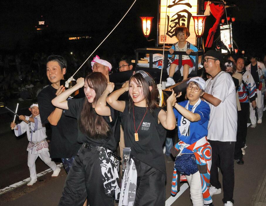 石川県輪島市の重蔵神社が金沢市でキリコ祭りを開き、練り歩く担ぎ手ら＝17日夜