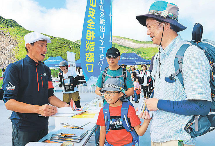 山岳警備隊員から山に登る際の注意点などを聞く登山者=室堂ターミナル