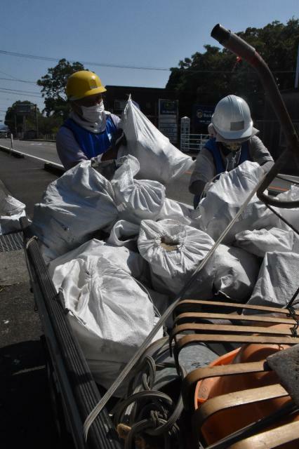 高齢者からの要請を受け、地震で崩れ落ちた屋根瓦を撤去するボランティア＝１３日午後、日南市東弁分