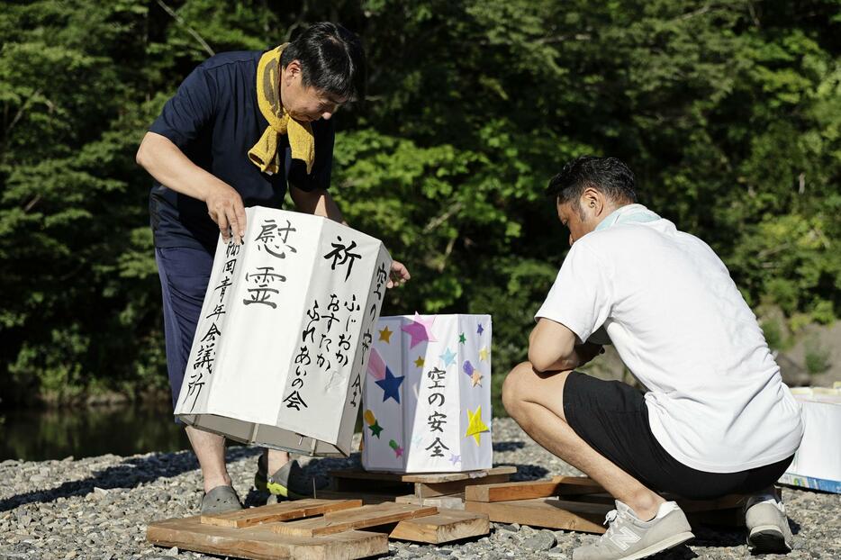 日航ジャンボ機墜落事故から39年となるのを前に、神流川の河原で灯籠を準備する人たち＝11日午後、群馬県上野村