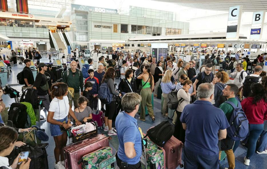 多くの旅行客らで混雑する羽田空港の国際線ターミナル。台風7号の接近で多くの便が欠航となった＝16日午前