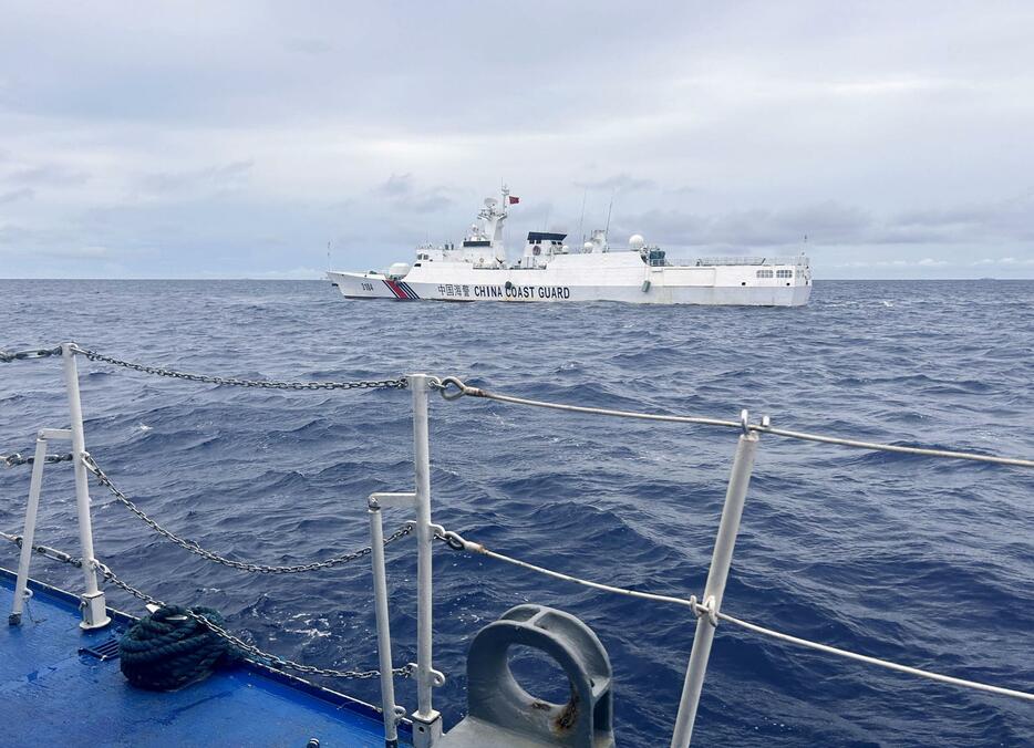 26日、南シナ海のサビナ礁の手前で、フィリピン沿岸警備隊の巡視船に接近する中国海警局の船（共同）