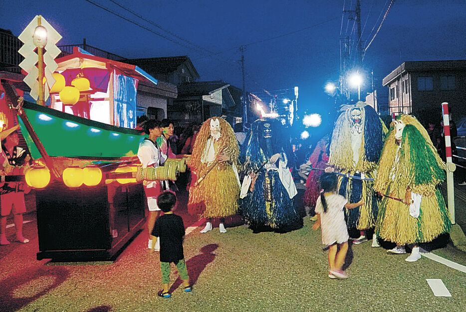 屋形船とともに練り歩く神の化身「アジロ」＝魚津市上村木地区