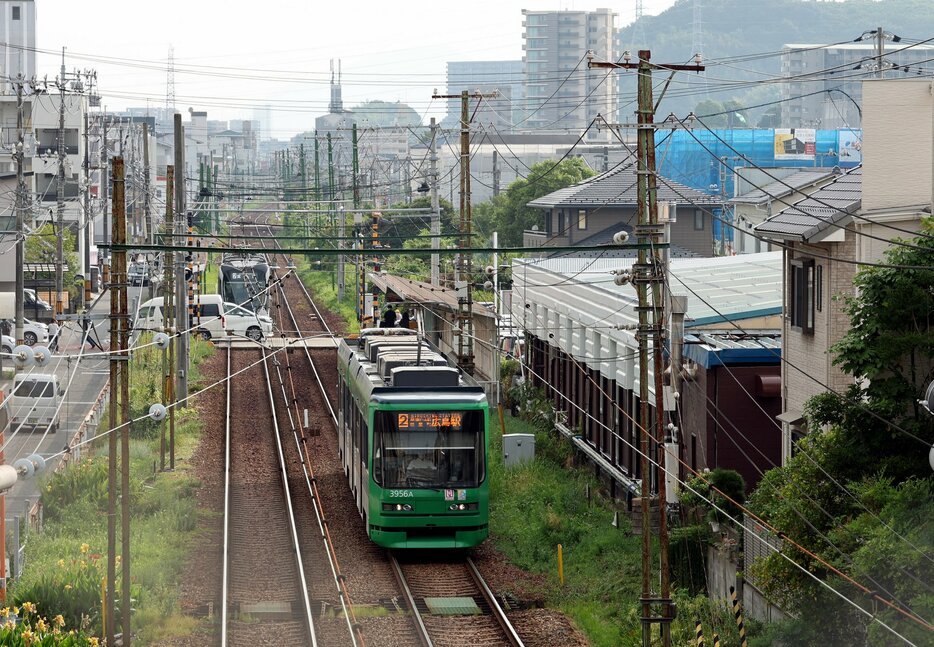 住宅建設の盛んな沿線を走る宮島線の電車＝広島市西区