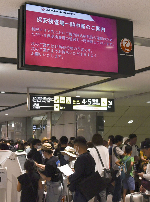 新千歳空港で保安検査中断の案内を表示するモニター＝17日午後