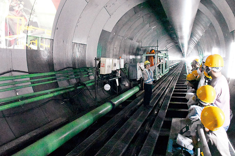 戸田市の「北大通り」地下で工事が進む、巨大な雨水貯留管内で担当者の説明を聞く参加者＝24日午前、戸田市内