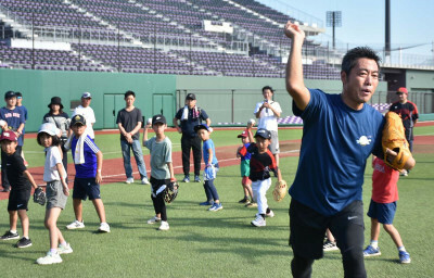 子どもたちにボールの投げ方を教える上原浩治さん（右）