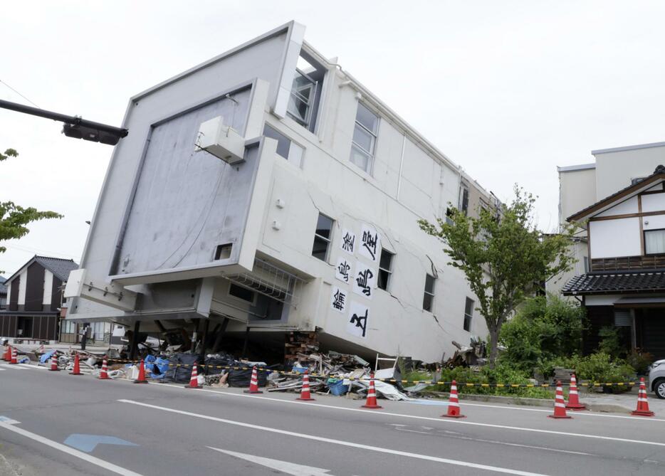 能登半島地震で倒壊し、横倒しのままとなっている石川県輪島市の7階建てビル＝22日午後