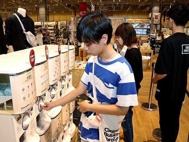 ガチャガチャを回す買い物客＝無印良品砺波