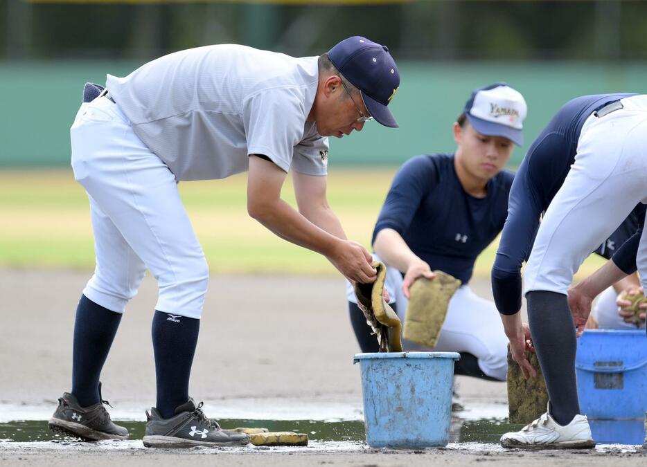 　控え選手に交じってグラウンドの水抜きを行う青森山田・兜森崇朗監督（撮影・伊藤笙子）