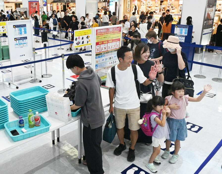 保安検査前に、手を振る帰省客ら＝１７日午後、霧島市の鹿児島空港