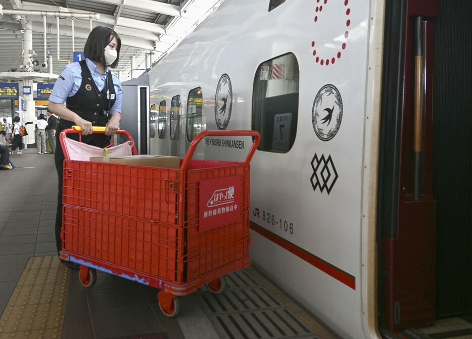 JR熊本駅で九州新幹線に荷物を積み込む「はやっ！便」の担当者＝9日