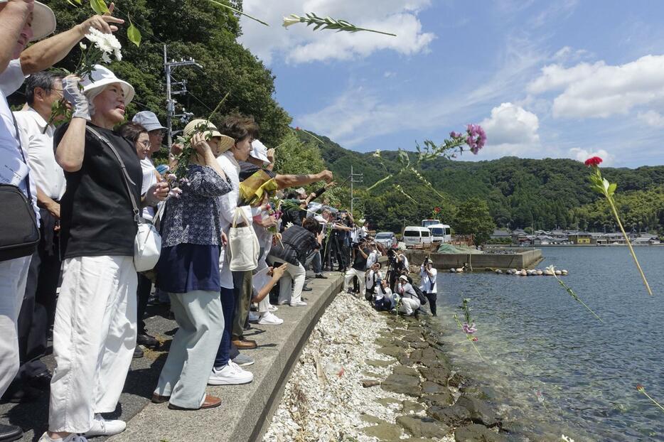 浮島丸が沈んだ海に花を投げ入れる追悼集会の参加者たち＝24日、京都府舞鶴市