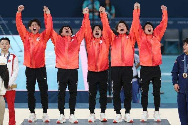 金メダル獲得で表彰台に上がる体操団体の選手たち(写真：青木紘二/アフロスポーツ)