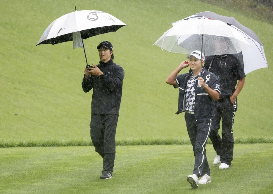 第2日、降雨順延となり、コースから引き揚げる石川遼（左）＝富士桜CC