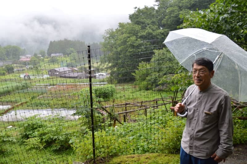 「大家」周辺を散策しながら山村の自然や暮らしについて語る細川春雄さん＝２０２４年６月２８日