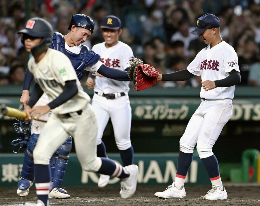 南陽工に勝利し、タッチを交わす栄田（右）と栗本の菰野バッテリー＝甲子園