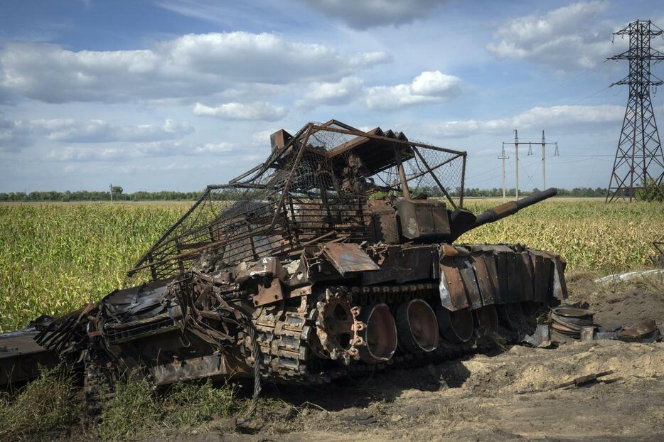 16日、ロシア西部クルスク州スジャ近郊で、道路脇に放置された、破壊されたロシア軍の戦車（AP＝共同）