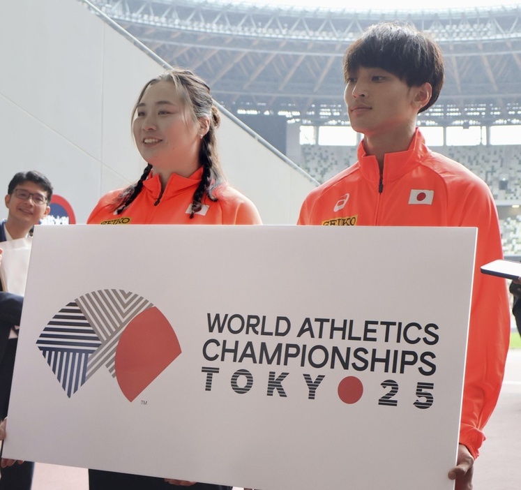 東京で開催される陸上世界選手権の大会ロゴを手に、取材に応じる女子やり投げの北口榛花（左）＝5月、東京・国立競技場