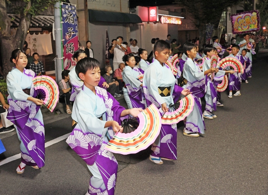 あでやかな扇子踊りを披露する子どもたち＝24日、津久見市のJR津久見駅前通り