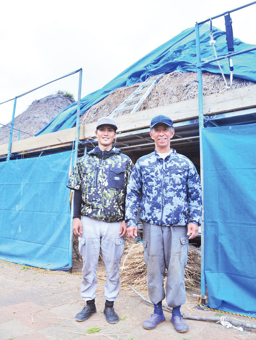 とおしめ公園の高倉のふき替え作業を指揮する中村博志さん（右）と弟子の辺木奎さん＝鹿児島県龍郷町浦