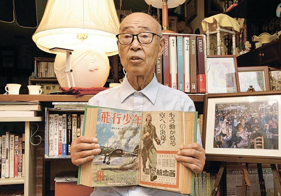 戦時中に買ってもらった月刊誌「飛行少年」を持ち、戦争について語る赤羽さん