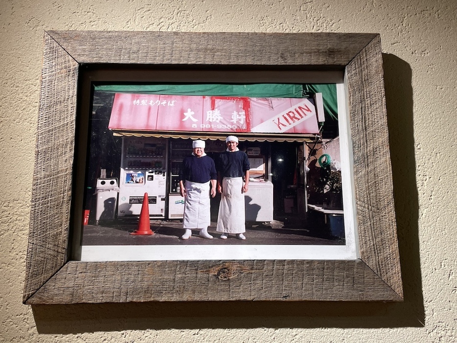 「東池袋大勝軒」（2007年閉店）前で撮影された、山岸さん（写真左）と田内川さん（写真右）の記念写真